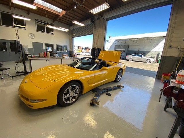 Yellow Corvette convertible in the bay on the clean, bright shop floor