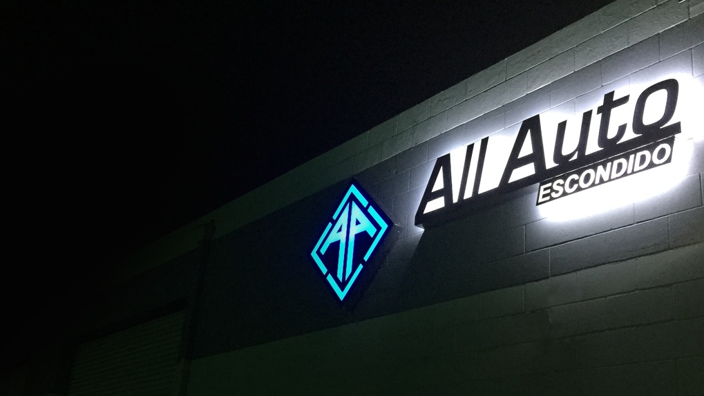 Illuminated All Auto Escondido sign glowing at night