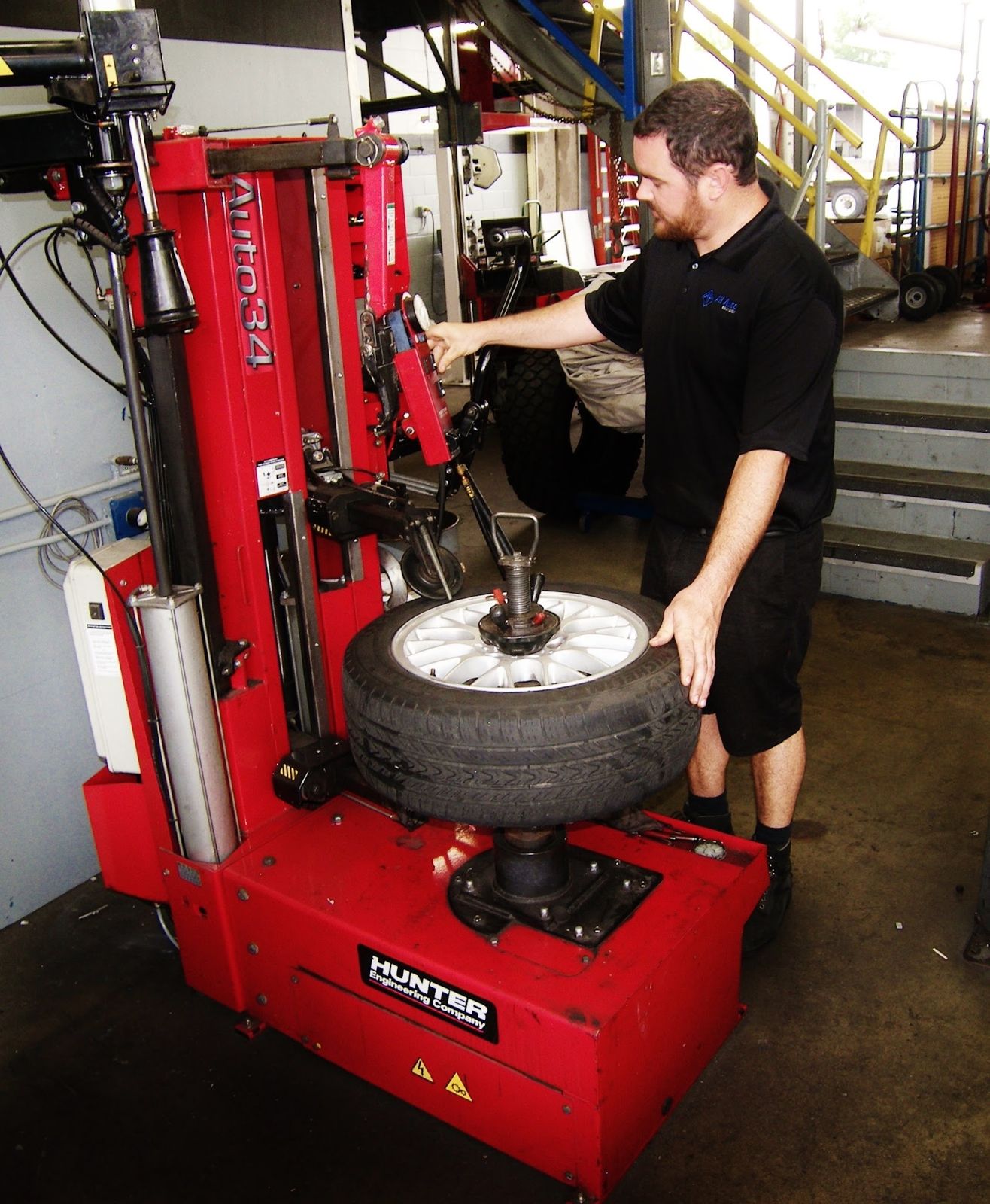 Technician working at the red tire changing machine